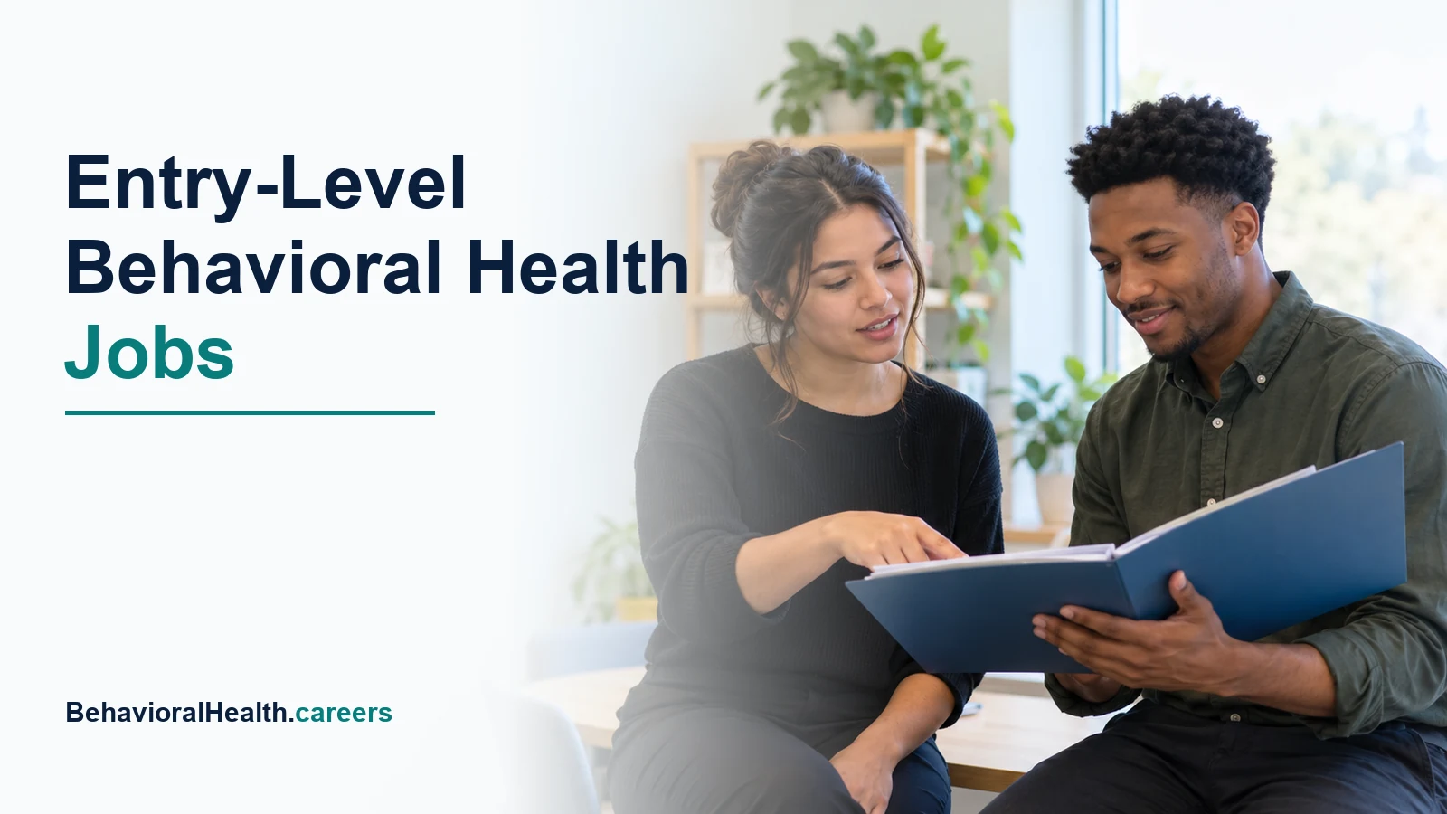 Two early-career behavioral health staff review an orientation folder.